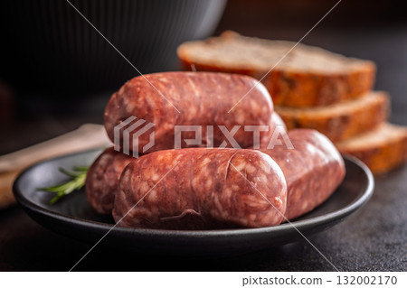 Photo of italian sausage salsiccia on plate on black table. 132002170