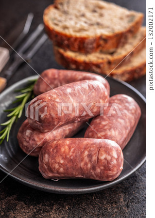 Photo of italian sausage salsiccia on plate on black table. Photo of italian sausage salsiccia on plate on black table. 132002171