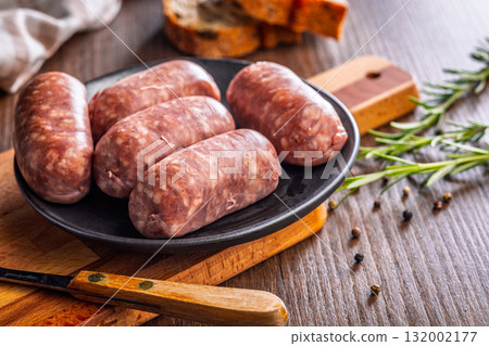 Photo of italian sausage salsiccia on plate on wooden table. 132002177