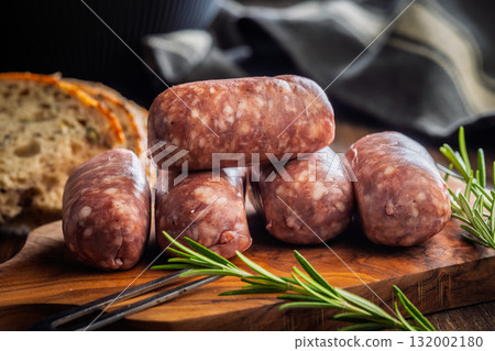 Photo of italian sausage salsiccia on cutting board on wooden table. Photo of italian sausage salsiccia on cutting board on wooden table. 132002180