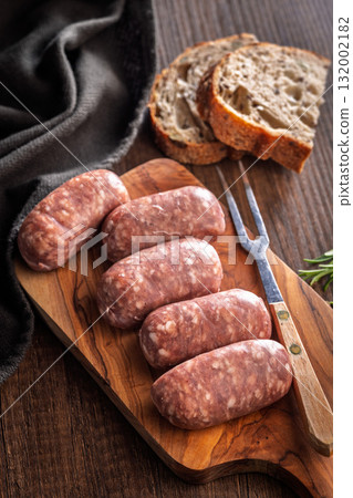 Photo of italian sausage salsiccia on cutting board on wooden table. 132002182