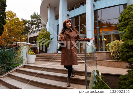 Autumn mood is captured as a young woman strolls alone, showing calm and emotional presence. 132002305