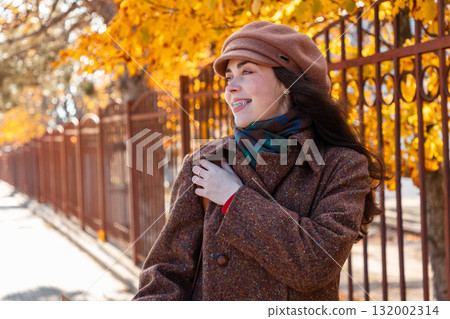 Portrait of young Caucasian woman wearing coat and cap with and walking at the city. Concept of psychology 132002314