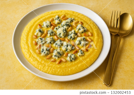 Creamy Polenta Topped With Blue Cheese and Pine Nuts Served on Yellow Tablecloth 132002453