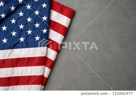 American Flag Draped on a Gray Surface, Symbolizing Patriotism and National Pride American Flag Draped on a Gray Surface, Symbolizing Patriotism and National Pride 132002477