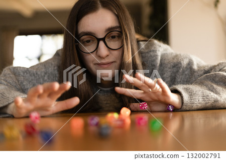 Woman placing a die on top of a tall stack of dice. Concept of focus success and challenge. 132002791