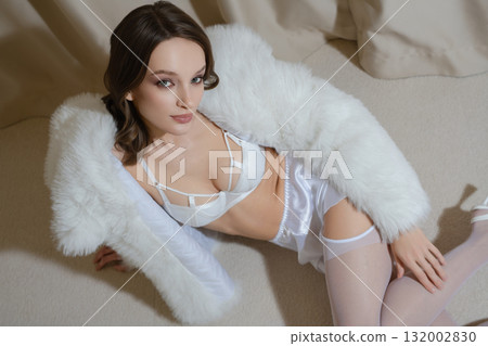 Woman in luxurious boudoir attire relaxing in a stylish hotel room Woman in luxurious boudoir attire relaxing in a stylish hotel room 132002830