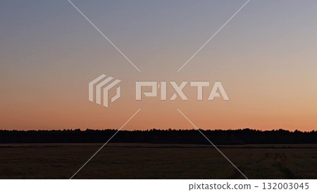 a beautiful sunset in a brown-orange hue, a young moon in the sky, and a horizon. beautiful sunset in the field. Beauty of nature, no people sunset. a beautiful sunset in a brown-orange hue, a young moon in the sky, and a horizon. beautiful sunset in the field. Beauty of nature, no people sunset. 132003045