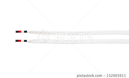 Close-up of white shoelaces with black and red tips on black background 132003811