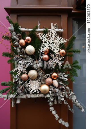Christmas composition of fir tree branches, balls, and pine cones on the door Christmas composition of fir tree branches, balls, and pine cones on the door 132003870