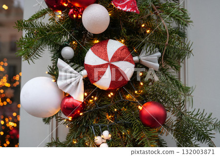 Christmas tree branches with red balls and a candy 132003871