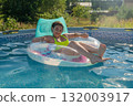 Young hispanic female relaxing on pool float in vibrant summer setting 132003917