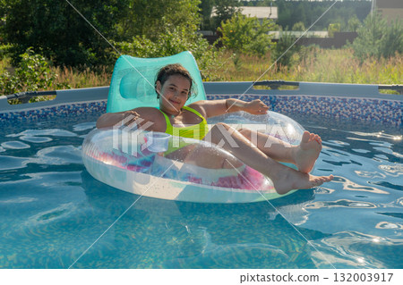 Young hispanic female relaxing on pool float in vibrant summer setting 132003917