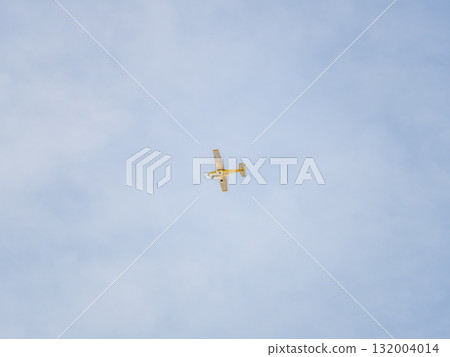 Small ultralight airplane with overhead wing and single propeller flying in sunset sky. Small ultralight airplane with overhead wing and single propeller flying in sunset sky. 132004014