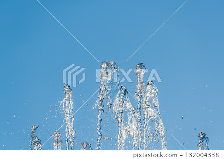 Splashes and jets of water against light background. Splashes and jets of water against light background. 132004338