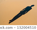 Human shadow cast gently across sandy ground.AI Generated 132004510