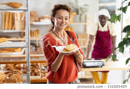 Joyful woman purchasing a bocadillo in a bakery Joyful woman purchasing a bocadillo in a bakery 132005405