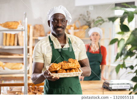 Portrait of positive man bakery worker with croissants Portrait of positive man bakery worker with croissants 132005518