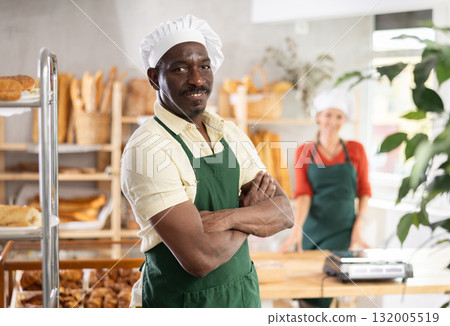 Portrait of professional smiling male baker in uniform in bakery 132005519