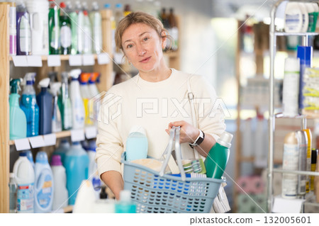 Woman selects various household cleaning products for cleaning house Woman selects various household cleaning products for cleaning house 132005601