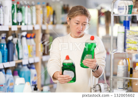 Woman customer diligently choosing out dishwashing liquid 132005602