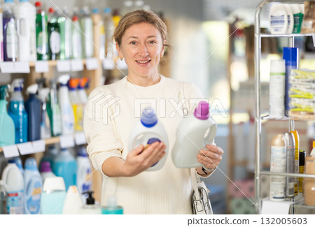 Woman consumer with household chemical products for washing indoors Woman consumer with household chemical products for washing indoors 132005603