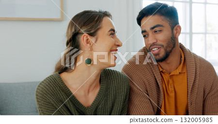 Love, smile and an interracial couple in their home on a sofa in the living room together to relax. Diversity, happy or romance with a young man and woman in their house for relationship bonding 132005985