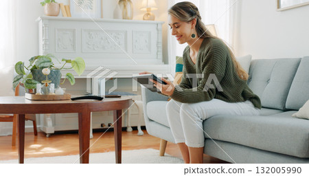 Happy woman, relaxing and smile with tablet in home while browsing, reading or online shopping. Canadian person, alone and casual with technology on sofa for internet, social media or mobile app 132005990