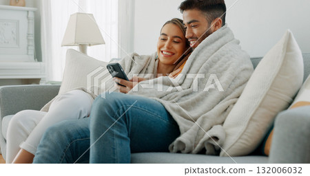 Happy couple, relax and post on social media with phone or communication, app or reading news together in home. Movie, video or streaming online with man and woman in living room with blanket on sofa 132006032