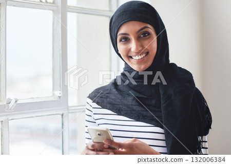 Creative muslim woman, phone and face smile for social media, communication or texting in startup at the office. Portrait of happy islamic girl smiling for online conversation on mobile smartphone Creative muslim woman, phone and face smile for social media, communication or texting in startup at the office. Portrait of happy islamic girl smiling for online conversation on mobile smartphone 132006384