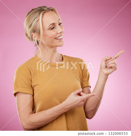 Happy, pointing and female model in studio to mockup for advertisement or product placement. Happiness, excited and woman from Canada showing with her finger mock up for marketing by pink background. 132006555