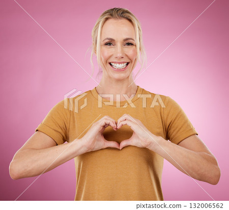 Heart, hands and portrait of woman on pink background, studio and color backdrop with emoji, care and kindness. Happy female model with finger shape for love, thank you and smile in support of peace Heart, hands and portrait of woman on pink background, studio and color backdrop with emoji, care and kindness. Happy female model with finger shape for love, thank you and smile in support of peace 132006562