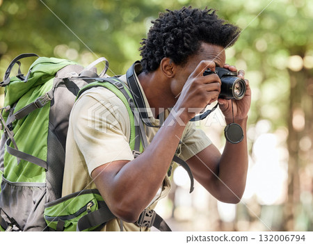 Fitness, black man and hiking with camera, forest and tourism in nature, capture moment and wilderness. African American male, hiker and tourist taking pictures, exercise and walking in mountains 132006794