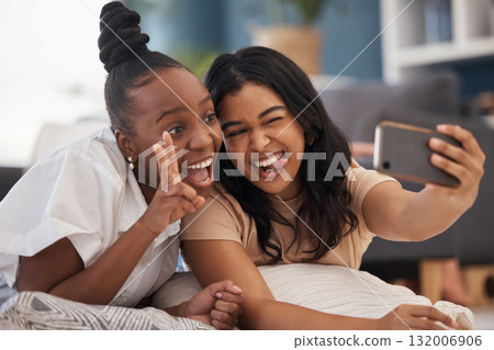 Friends, selfie and happy, face and peace sign in a living room while bonding and having fun. Social media, influencer and women smile for profile picture, post or blog photo with emoji expression Friends, selfie and happy, face and peace sign in a living room while bonding and having fun. Social media, influencer and women smile for profile picture, post or blog photo with emoji expression 132006906