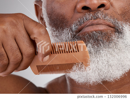 Senior black man, hands and beard with comb in grooming, beauty or skincare hygiene against a studio background. Closeup of African elderly male face combing or brushing facial hair in clean wellness 132006996