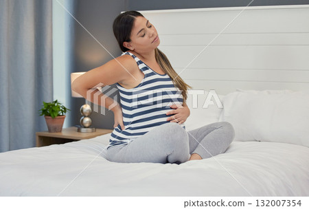 Pregnant, bed and woman with back pain, maternity issues and anxiety with ache, muscle strain and cramps. Pregnancy, female or lady in bedroom, contractions and anxious with health problems or stress Pregnant, bed and woman with back pain, maternity issues and anxiety with ache, muscle strain and cramps. Pregnancy, female or lady in bedroom, contractions and anxious with health problems or stress 132007354