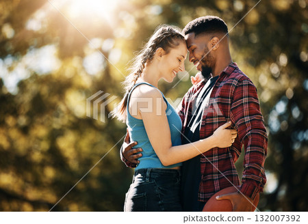 Interracial couple, outdoor park and love with a hug for commitment, care and nature in summer. Black man and woman together for support, security and date for quality time with trees and lens flare Interracial couple, outdoor park and love with a hug for commitment, care and nature in summer. Black man and woman together for support, security and date for quality time with trees and lens flare 132007392