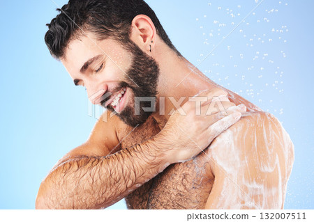 Shower, cleaning and man with soap, smile and water splash in studio for wellness, hygiene and grooming. Skincare, healthy skin and male with foam, cosmetics and washing body on blue background Shower, cleaning and man with soap, smile and water splash in studio for wellness, hygiene and grooming. Skincare, healthy skin and male with foam, cosmetics and washing body on blue background 132007511