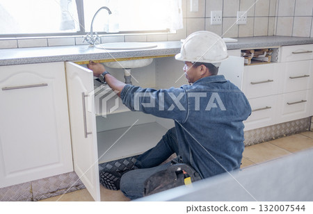 Sink repair, home maintenance and kitchen water pipe check of handyman in a house. Contractor man, builder service and filter improvement installation of a construction employee working in household Sink repair, home maintenance and kitchen water pipe check of handyman in a house. Contractor man, builder service and filter improvement installation of a construction employee working in household 132007544