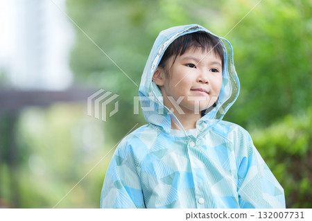 Child wearing a raincoat on a rainy day Child wearing a raincoat on a rainy day 132007731