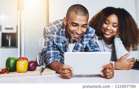 Happy couple, tablet and cooking healthy meal with recipe in kitchen at home on internet, website and online connection. Man, African woman and technology for reading instructions on vegan food blog 132007790