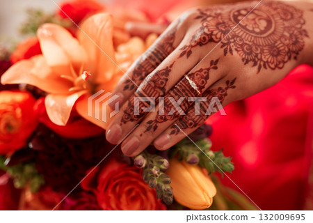 Henna, hand and Indian bride at her wedding event with flowers or bouquet for decoration or design. Event, marriage and creative female person or woman with art pattern on her hand for celebration 132009695