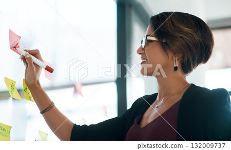 Business woman, writing and brainstorming on glass moodboard for ideas, planning workflow and project goals. Happy professional worker or person, sticky notes and creative schedule or job reminder 132009737