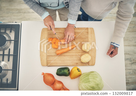 Cooking, vegetables and couple hands cook food in a kitchen for healthy, vitamins and nutritions diet in a home. Meal, overhead and people preparing fresh produce together on cutting board for dinner Cooking, vegetables and couple hands cook food in a kitchen for healthy, vitamins and nutritions diet in a home. Meal, overhead and people preparing fresh produce together on cutting board for dinner 132009817