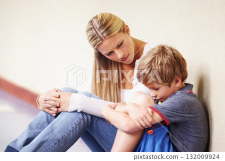 Teacher, sad student and talking at school for support, trust or counselling. A woman working with a child for discussion or education about bullying, learning problem and development in hallway 132009924