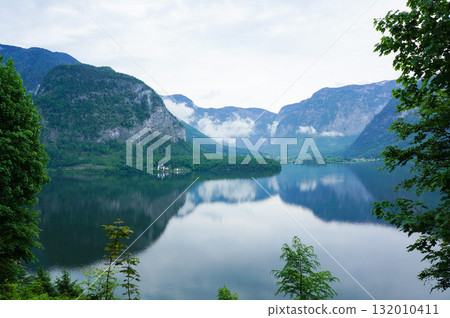 Beautiful scenery of Hallstatt with cloudy skies and majestic mountains Beautiful scenery of Hallstatt with cloudy skies and majestic mountains 132010411