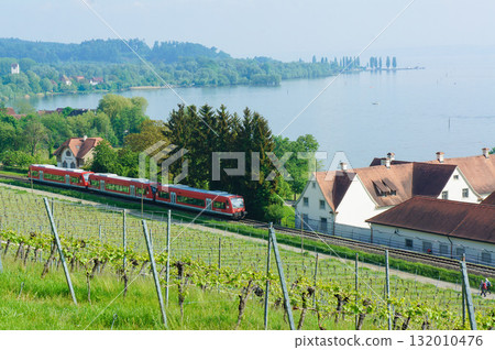 A train passing through a rural town with a lake A train passing through a rural town with a lake 132010476