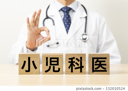 A block with the word "pediatrician" written on it and a doctor making an OK sign A block with the word "pediatrician" written on it and a doctor making an OK sign 132010524