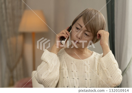 一位老年婦女在家中回應可疑電話 一位老年婦女在家中回應可疑電話 132010914