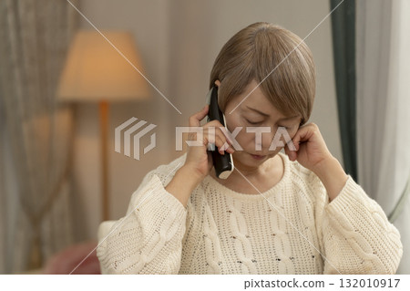 一位老年婦女在家中回應可疑電話 一位老年婦女在家中回應可疑電話 132010917